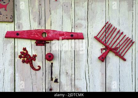 Old Shed Door mit Metal Junk dekoriert, darunter Toy Metal Lizard und Old Rake Head auf Boat Shed am Bregancon Beach Var Provence France Stockfoto