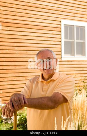 Ein älterer Mann steht vor dem Haus Stockfoto