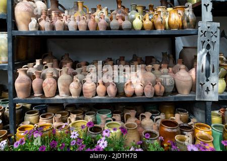 Viele einzigartige handgemachte bunte Tonkannen und Vasen in verschiedenen Formen im Regal auf dem lokalen Markt Stockfoto