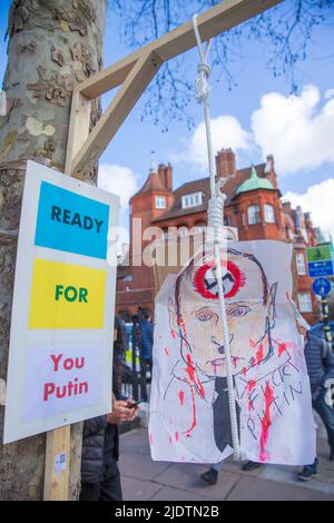 Plakate und Plakate gegen den russischen Präsidenten Wladimir Putin und seine Invasion in der Ukraine sind in der Nähe der russischen Botschaft in London zu sehen. Stockfoto