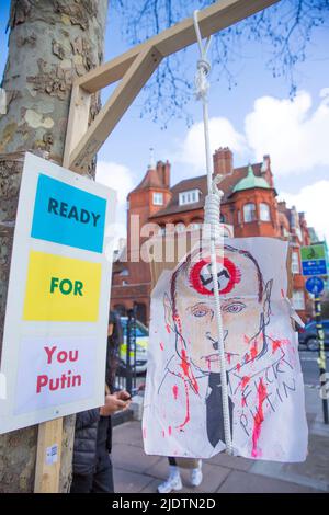 Plakate und Plakate gegen den russischen Präsidenten Wladimir Putin und seine Invasion in der Ukraine sind in der Nähe der russischen Botschaft in London zu sehen. Stockfoto