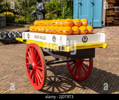 Ein historischer Wagen mit einem Stapel runder Edam-Käsesorten, eine Ausstellung vor dem Wiegehaus (kaaswaag), Edam, Nordholland, Niederlande. Stockfoto