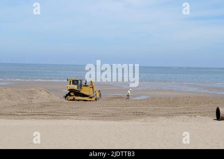 Gelbe Bulldozer an einem Strand Stockfoto