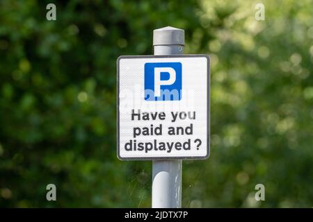 „Haben Sie bezahlt und angezeigt?“ Erinnerungszeichen auf einem britischen Parkplatz, dass Fahrer zahlen müssen, um ihr Fahrzeug zu parken. England, Großbritannien Stockfoto