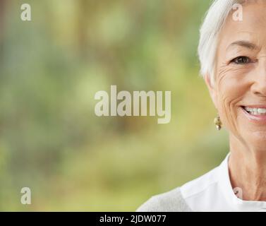 Porträt einer glücklichen älteren kaukasischen Frau mit Copyspace. Das Gesicht einer unbeschwerten, fröhlichen Frau im Ruhestand, die an der Kamera lächelt. Sorglos, entspannt und Stockfoto