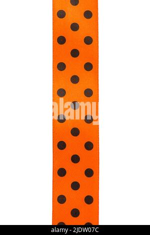 Halloween-Konzept. Orangefarbenes Band mit schwarzen Erbsen isoliert auf einem Bill Hintergrund. Stockfoto