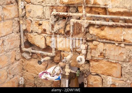 Alte rostige Wasserleitungen und Abwasserleitungen in einem alten Gebäude freigelegt Stockfoto