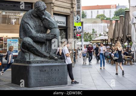 Nikola Tesla-Statue, die eine Frau mit einem Mobiltelefon betrachtet, Zagreb, Kroatien Stockfoto