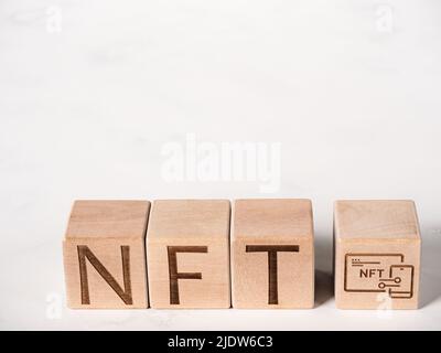 Text NFT auf Holzklötze als Konzept der Verwendung nicht-fungibler Token Stockfoto