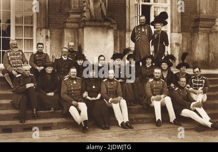 1912 ca. , Potsdam , Deutschland: Seltenes komplet-Familienporträt des deutschen Kaisers und Königs von Preußen Kaiser WILHELM II. ( Guglielmo II. ) HOHENZOLLERN ( Berlin 1859 - Doorn , Utrecht 1941 ), oben auf der Treppe stehend mit seiner Frau Kaiserin AUGUSTE VICTORIA von Schleswig - Holstein ( 1858 - 1921 ). Die Kaiser haben 7 Söhne, alle in diesem Foto mit Ehefrauen. Auf der ersten Treppe, unten in der Mitte des Fotos, der Prinz erblich Kronprinz WILHELM FRIEDERICH ( 1882 - 1951 ) mit Frau Herzogin CECILIE von Maclemburg - Schwerin ( niece der russischen Zar Alexander II , 1886 - 1954 ), Prinz ADALBERT ( 1884 - 1 Stockfoto