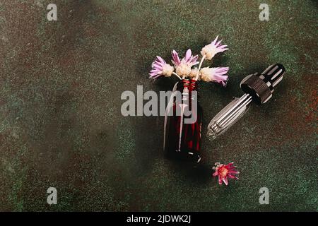 Abstraktes Kosmetiklabor. Flaschen aus dunklem bernsteinfarbenem Glas auf einem grünen Podium-Hintergrund. Naturkosmetik für Pflege, Homöopathie. Stockfoto