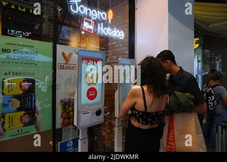 Personen, die einen digitalen Bestellkiosks mit Touchscreen im Jongro-Reis-Hotdog in Manhattans Koreatown, New York, nutzen. Stockfoto