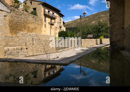 Spiegelung der Gebäude im Wasser eines alten Waschplatz, Mirambel, Teruel, Spanien Stockfoto