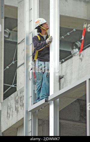 Hochhaus-Konstruktion aus Eisen und Stahl und Zement mit Arbeitern in Sicherheit Ausrüstung Stockfoto