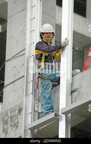 Hochhaus-Konstruktion aus Eisen und Stahl und Zement mit Arbeitern in Sicherheit Ausrüstung Stockfoto