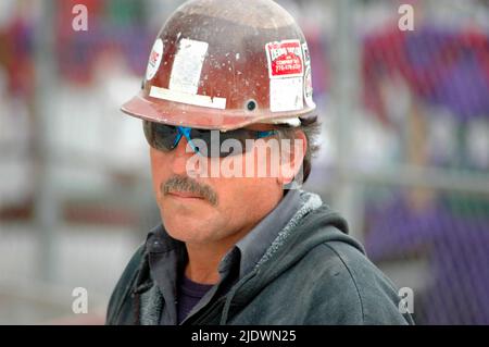 Hochbauweise aus Eisen, Stahl und Zement mit Arbeitern in Sicherheitsausrüstung bei der Arbeit Stockfoto