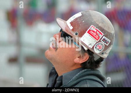 Hochbauweise aus Eisen, Stahl und Zement mit Arbeitern in Sicherheitsausrüstung bei der Arbeit Stockfoto