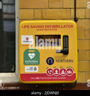 Ein Notfall-Defibrillator oder ein Herzrestaurant für den öffentlichen Gebrauch an einer Wand in Manchester, England, Großbritannien. Stockfoto