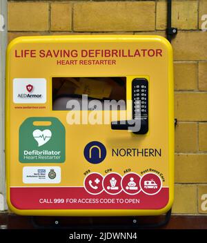 Ein Notfall-Defibrillator oder ein Herzrestaurant für den öffentlichen Gebrauch an einer Wand in Manchester, England, Großbritannien. Stockfoto