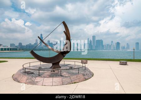 Chicago, Illinois, USA - 25. August 2014: Sonnenuhr-Skulptur, heißt is man begibt sich in den Kosmos mit Lake Michigan und Chicagos Skyline im Hintergrund. Stockfoto