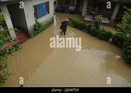 Srinagar, Jammu und Kaschmir, Indien: 22. Juni 2022, 22. Juni, 2022, Srinagar, Jammu und Kashmir, Indien: Nach unaufhörlichen Niederschlägen in Pattan nördlich von Srinagar, Kaschmir, fließt Hochwasser durch das Wohngebiet. Schwere Regenfälle haben in den letzten Tagen Teile der Region überschwemmt, Überschwemmungen und Erdrutsche ausgelöst und zur Schließung der strategischen Nationalstraße Jammu-Srinagar führen können. Die Schulen wurden als Vorsichtsmaßnahme geschlossen.das Meteorologische Büro hat die Menschen gewarnt, nicht in die Nähe schlampiger Kallas zu gehen oder zu arbeiten, da es oft plötzlich zu einer Sturzflut kommt. (Bild: © Sa Stockfoto
