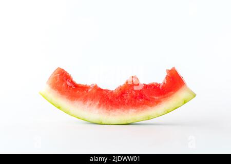 Nahaufnahme einer meist gefressenen Wassermelonenscheibe, isoliert vor weißem Hintergrund. Stockfoto