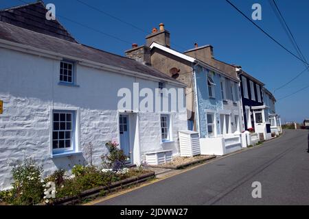 Reihe von Steinhütten Häuser Häuser entlang einer Straße mit Blick auf das Meer mit blauem Himmel im Sommer Juni 2022 New Quay Ceredigion Wales Großbritannien KATHY DEWITT Stockfoto