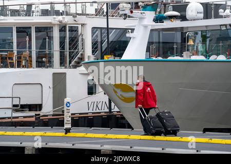 Flusskreuzfahrtschiffe am Kai der IJ, in der Nähe des Hauptbahnhofs, Gepäck der Passagiere wird verladen, Amsterdam, Niederlande Stockfoto