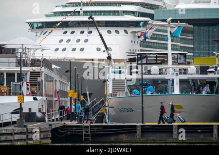 Flusskreuzfahrtschiffe am Kai der IJ, in der Nähe des Hauptbahnhofs, Gepäck der Passagiere wird verladen, Amsterdam, Niederlande Stockfoto