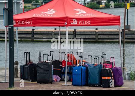 Flusskreuzfahrtschiffe am Kai der IJ, in der Nähe des Hauptbahnhofs, Gepäck der Passagiere wird verladen, Amsterdam, Niederlande, Stockfoto