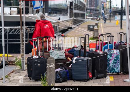 Flusskreuzfahrtschiffe am Kai der IJ, in der Nähe des Hauptbahnhofs, Gepäck der Passagiere wird verladen, Amsterdam, Niederlande, Stockfoto