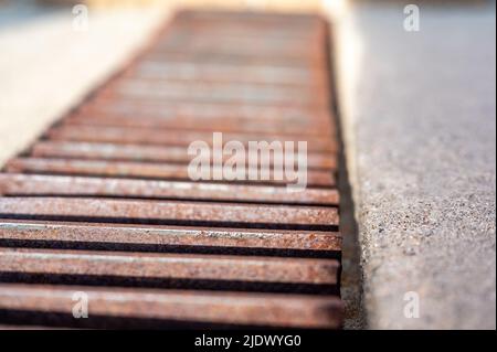 Rost über einem Regenwassergruben in einer Betonplatte. Stockfoto