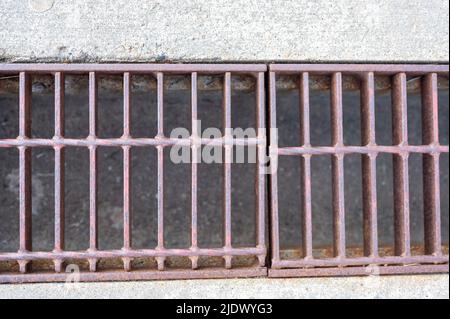 Rost über einem Regenwassergruben in einer Betonplatte. Stockfoto