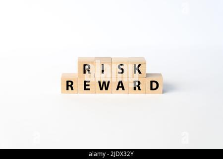 Die Konzepte von Risiko und Rendite wurden mit Holzblöcken auf weißem Hintergrund geschrieben Stockfoto