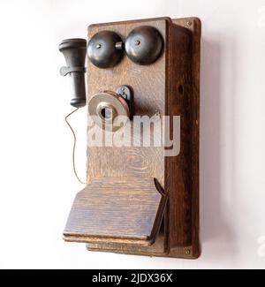 Altes antikes, veraltetes Telefon mit Wandmontage aus Holz Stockfoto