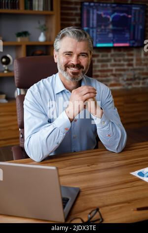 Geschäftsporträt eines selbstbewussten, gut aussehenden bärtigen Geschäftsmanns, der die Kamera anschaut und lächelt. Nahaufnahme des kaukasischen grauhaarigen Mannes von vorne Stockfoto