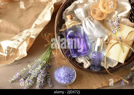 Korb mit einer Probe von natürlichen Lavendel Körperpflegeprodukten auf Holztisch und Fensterhintergrund. Draufsicht. Horizontale Zusammensetzung. Stockfoto