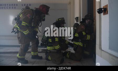 Feuerwehrleute mit der Callaway Feuerwehr bereiten sich auf den Eintritt in ein simuliertes brennendes Gebäude in Panama City, Florida, 16. Juni 2022 vor. Zum ersten Mal seit mehr als 30 Jahren kamen Feuerwehrleute aus mehreren Behörden in Bay County zusammen, um zu trainieren, darunter das 325. Civil Engineer Squadron, der Tyndall Air Force Base und die Naval Support Activity Panama City. (USA Foto der Luftwaffe von Staff Sgt. Stefan Alvarez) Stockfoto