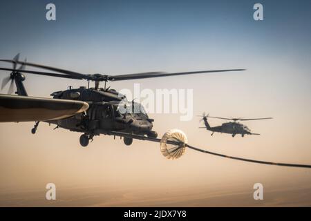 Ein 332d Air Expeditionary Wing HH-60G Pave Hawk Hubschrauber erhält Treibstoff von einem HC-130J Combat King II Flugzeug, das ebenfalls dem 332d AEW zugewiesen wurde, in Südwestasien, 12. Juni 2022. Die primäre Aufgabe des Pave Hawk besteht darin, Tag- oder Nachteinsätze zur Wiederherstellung von Personal in feindlichen Umgebungen durchzuführen, um isoliertes Personal während eines Konflikts zu erholen. Die HH-60G ist auch mit militärischen Operationen außer Konflikten beauftragt, einschließlich zivile Such- und Rettungsmaßnahmen, medizinische Evakuierung, Katastrophenhilfe, humanitäre Hilfe, Sicherheitskooperation/Luftverkehrsberatung, NASA Raumfahrt Unterstützung und Rettung c Stockfoto