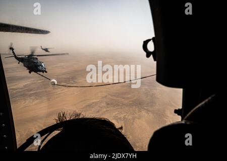 Ein 332d Air Expeditionary Wing HH-60G Pave Hawk Hubschrauber erhält Treibstoff von einem HC-130J Combat King II Flugzeug, das ebenfalls dem 332d AEW zugewiesen wurde, in Südwestasien, 12. Juni 2022. Die primäre Aufgabe des Pave Hawk besteht darin, Tag- oder Nachteinsätze zur Wiederherstellung von Personal in feindlichen Umgebungen durchzuführen, um isoliertes Personal während eines Konflikts zu erholen. Die HH-60G ist auch mit militärischen Operationen außer Konflikten beauftragt, einschließlich zivile Such- und Rettungsmaßnahmen, medizinische Evakuierung, Katastrophenhilfe, humanitäre Hilfe, Sicherheitskooperation/Luftverkehrsberatung, NASA Raumfahrt Unterstützung und Rettung c Stockfoto