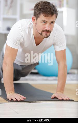 Selbstbewusster muskulös junger Mann trägt Sportbekleidung Training im Fitnessstudio Stockfoto