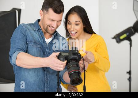 Fotograf und Model überprüfen Fotos auf der Kamera Stockfoto