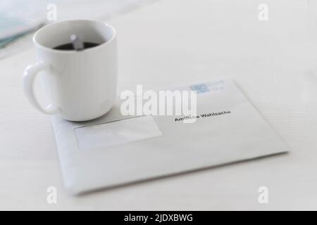 Briefumschlag mit Kaffeetasse auf dem Tisch Stockfoto