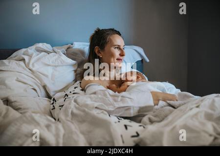 Baby schläft auf Mutter zu Hause Stockfoto