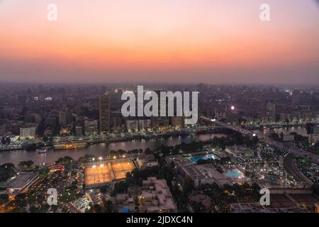 Ägypten, Kairo, erhöhte Ansicht der Bezirke Gezira, Agouza, Dokki und Mohandeseen in der Abenddämmerung mit Sportvereinen im Vordergrund Stockfoto