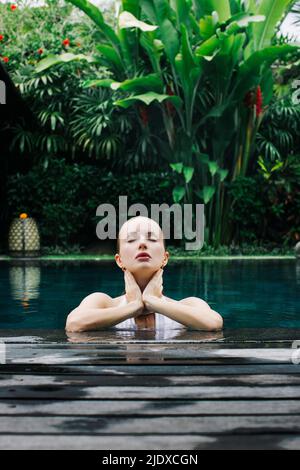 Indonesien, Bali, Porträt einer jungen Frau, die sich im Pool entspannt Stockfoto