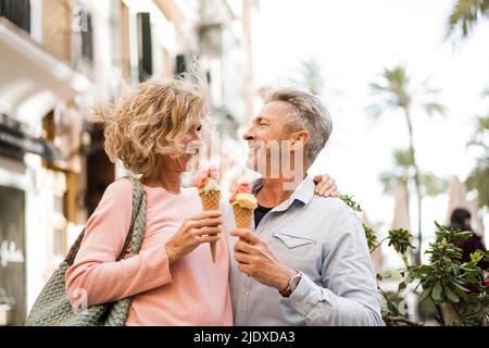 Glückliches reifes Paar, das Eis in der Stadt hatte Stockfoto