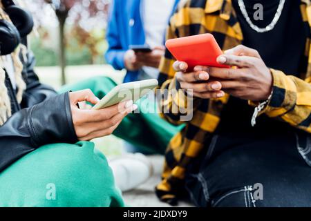Multirassische Freunde, die Smartphone verwenden Stockfoto