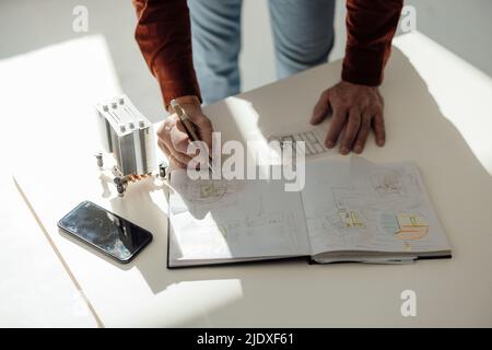 Hand eines Geschäftsmannes, der an der Rezeption ein Tagebuch schrieb Stockfoto