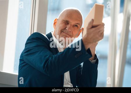 Leitender Geschäftsmann analysiert Holzklotz im Büro Stockfoto